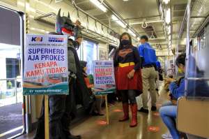 Superhero Naik KRL Ajak Penumpang Tertib Prokes